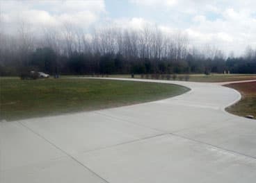 Long curved concrete driveway with clean control joints on a rural Tennessee property