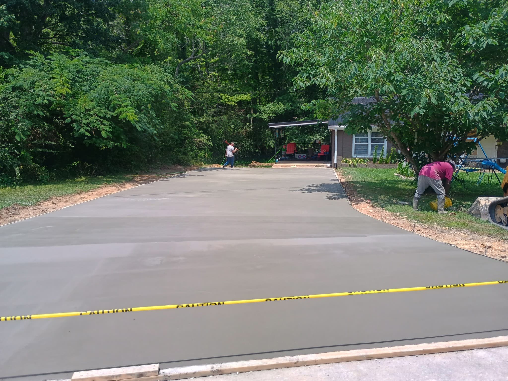 Freshly poured concrete driveway with smooth broom finish curing in Summertown, TN
