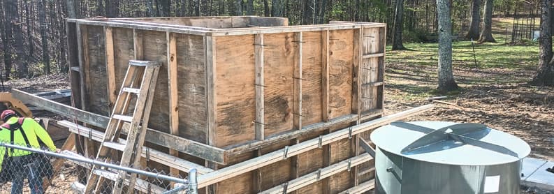 Custom wooden formwork set up for a concrete storm shelter pour in rural Tennessee