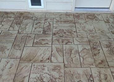 Stamped concrete patio with Ashlar slate pattern and warm brown color tones at a residential home