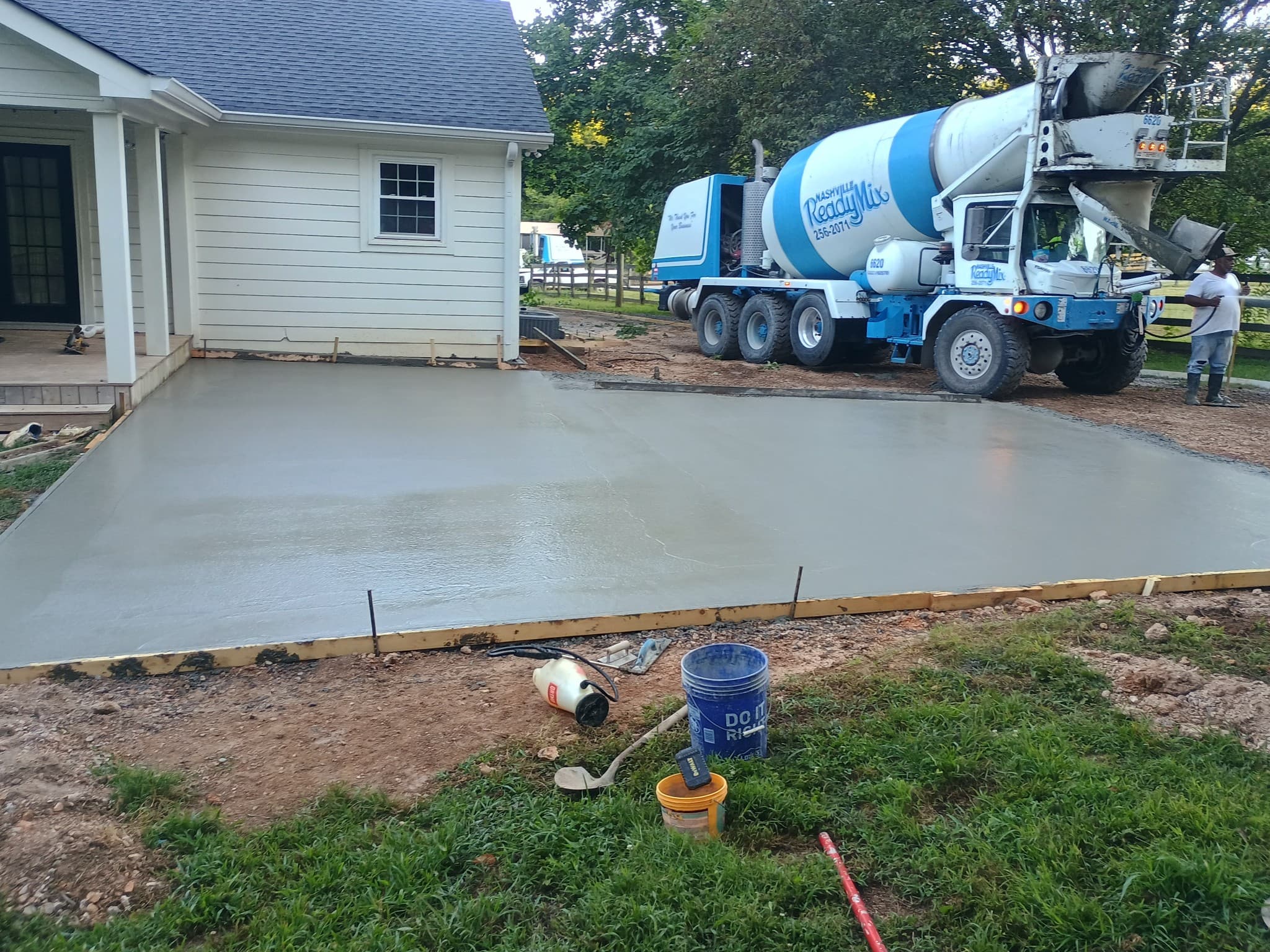 Large concrete patio slab being poured next to a home with ready-mix truck on site in Tennessee
